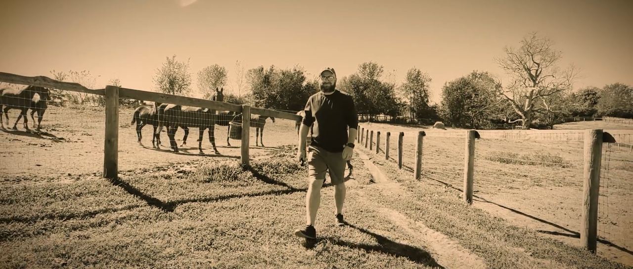 Kenneth Stevenson walking through a horse pasture